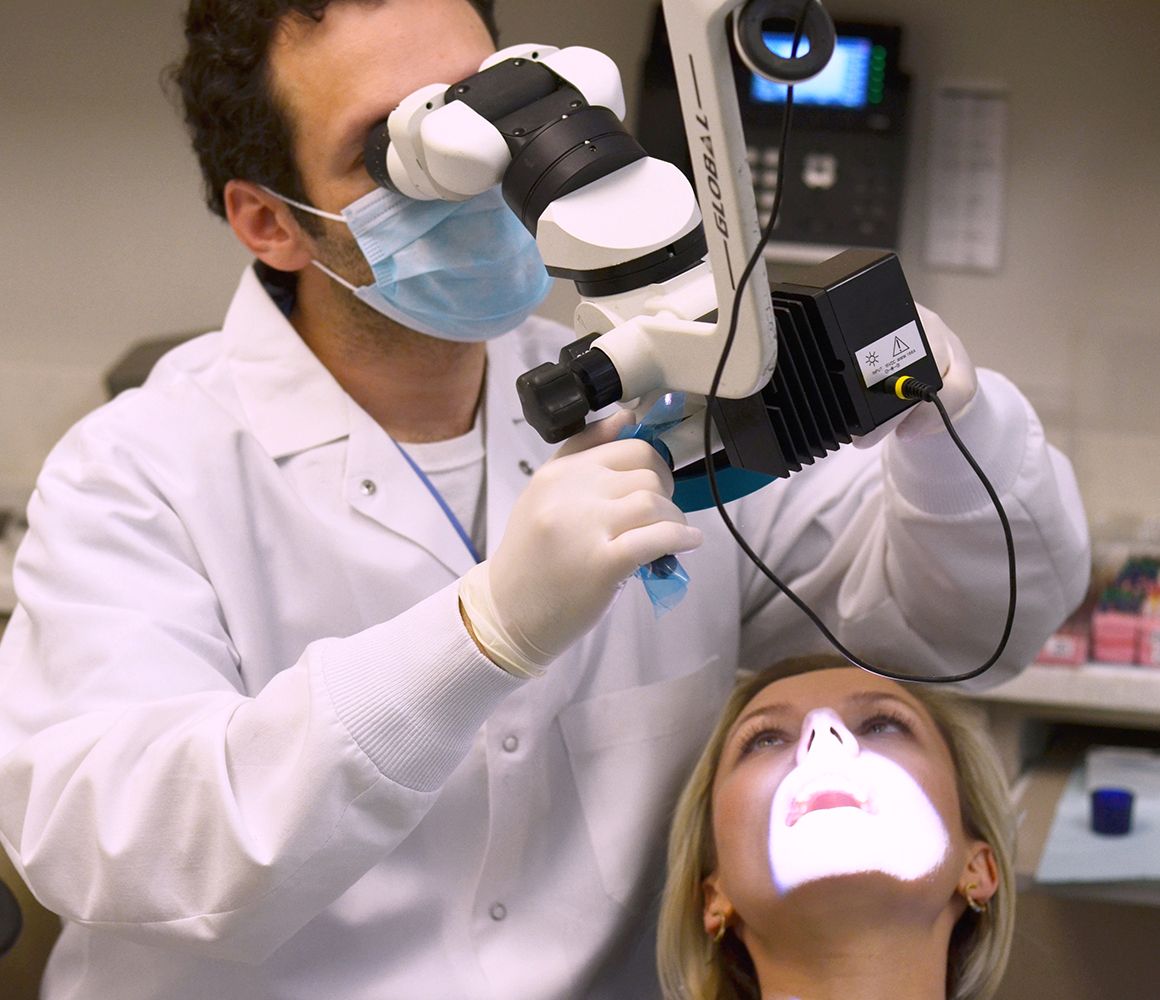 A dental professional performing a root canal in NYC