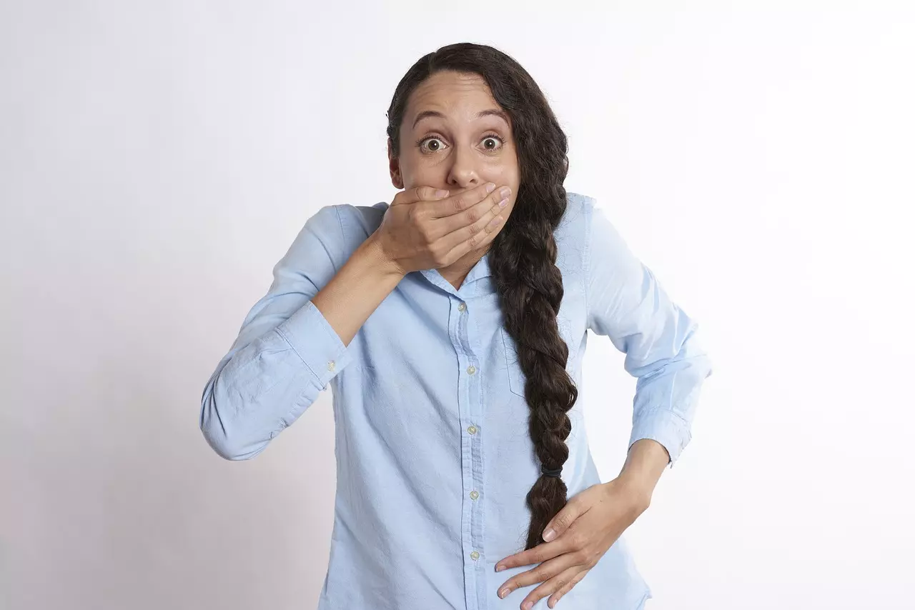 A woman with her hand over her mouth after hearing common dental myths
