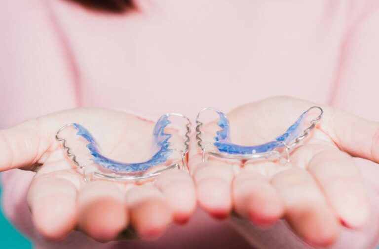 Hands holding Hawley retainers
