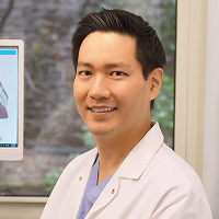 Dr. Sang (Ben) Ahn holding false teeth
