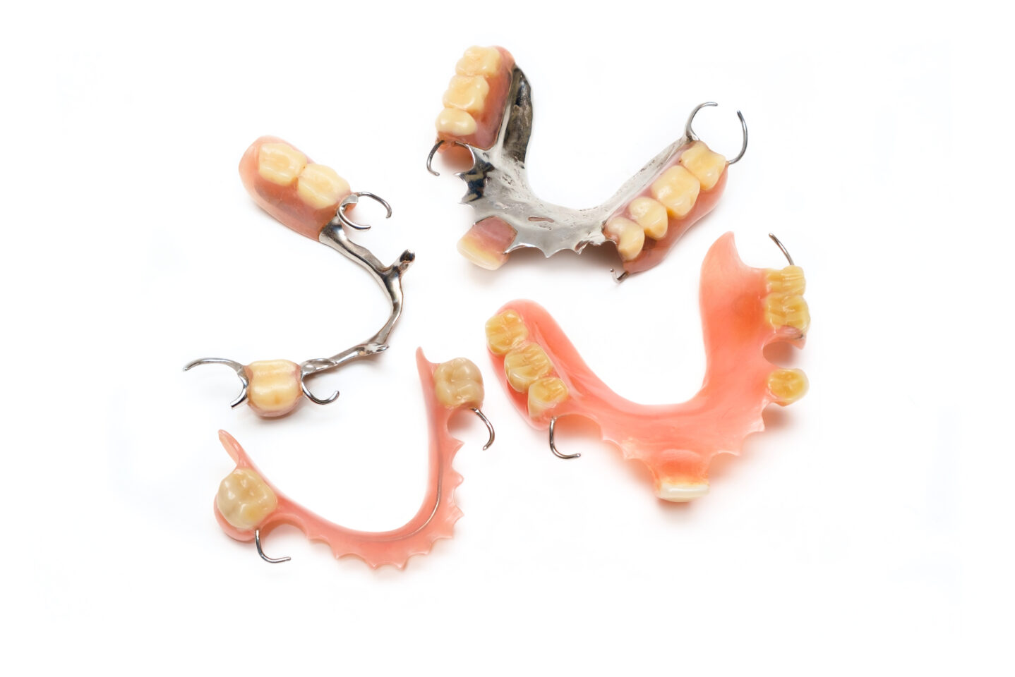 Examples of different types of partial dentures: upper & lower cast metal dentures, upper and lower acrylic dentures with metal hooks