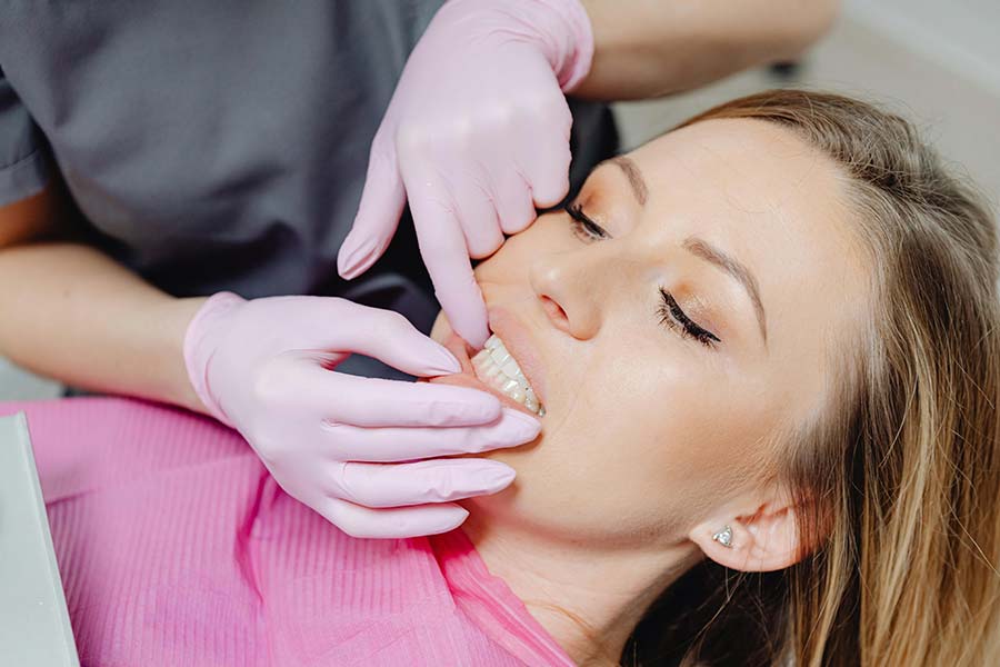A dentist examining the effects of whitening strips on a patient